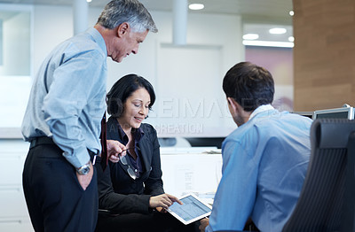 Buy stock photo Shot of a young businesswoman showing her colleagues something on a tablet