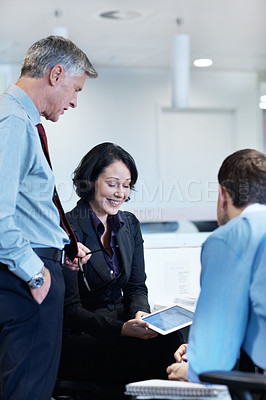 Buy stock photo Shot of a young businesswoman showing her colleagues something on a tablet