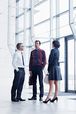 Buy stock photo Shot of three businesspeople having a conversation indoors