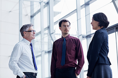 Buy stock photo Shot of three businesspeople having a conversation indoors