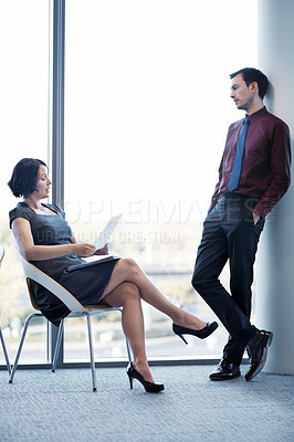 Buy stock photo Shot of a young businesswoman reading a report to her colleague