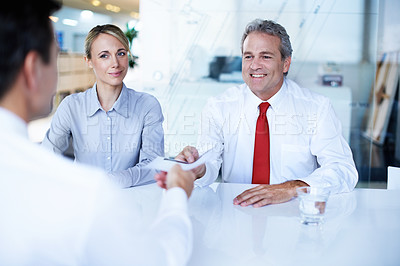 Buy stock photo Shot of a group of businesspeople discussing paperwork in an office