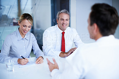 Buy stock photo Over the shoulder shot of a group of businesspeople talking while sitting in an office