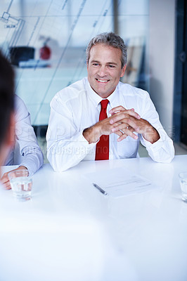 Buy stock photo Over the shoulder shot of a group of businesspeople discussing documents in an office