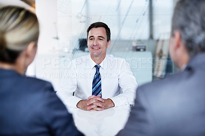 Buy stock photo Over the shoulder shot of a group of businesspeople talking while sitting in an office