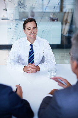 Buy stock photo Over the shoulder shot of a group of businesspeople having a meeting in an office