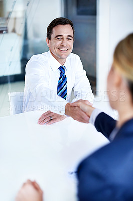 Buy stock photo Over the shoulder shot of a group of businesspeople shaking hands in an office