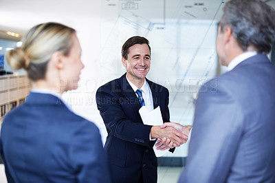Buy stock photo Over the shoulder shot of a group of businesspeople shaking hands in an office
