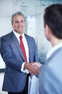 Buy stock photo Shot of two businessmen shaking hands in an office