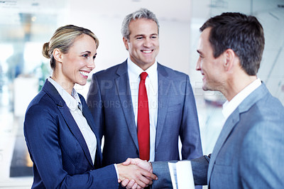 Buy stock photo Shot of two businesspeople shaking hands while standing in an office