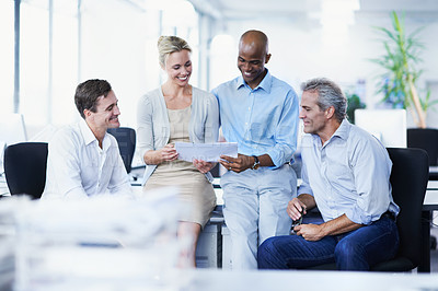 Buy stock photo Shot of a group of businesspeople discussing paperwork in office