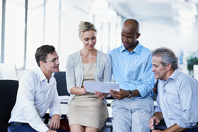 Buy stock photo Shot of a group of businesspeople discussing paperwork in office