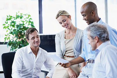 Buy stock photo Shot of a diverse group of businesspeople discussing paperwork in an office