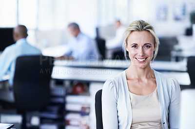 Buy stock photo Shot of a woman working sitting in an office with colleagues in the backgroud
