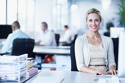 Buy stock photo Portrait of a woman working at her computer in an office with colleagues in the backgroud