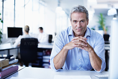 Buy stock photo Portrait of a mature businessman sitting at his desk in an office