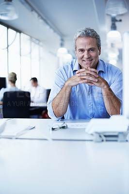 Buy stock photo Portrait of a mature businessman sitting at his desk in an office
