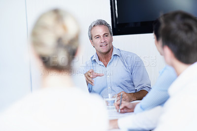 Buy stock photo Shot of a group of colleagues having a meeting around a boardroom table