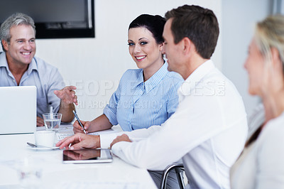 Buy stock photo Portrait of an attractive woman sitting in an office with colleagues during a meeting