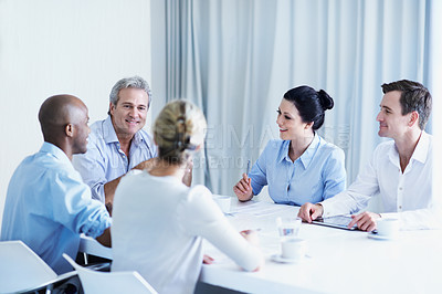Buy stock photo Shot of a group of colleagues brainstorming around a boardroom table