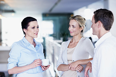 Buy stock photo Shot of a group of coworkers chatting over a coffee in an office