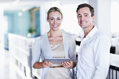 Buy stock photo Portrait of two coworkers working with a digital tablet standing in an office