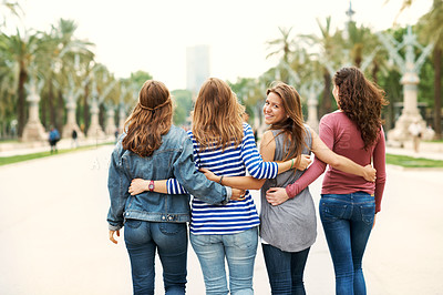 Buy stock photo Rear view of some happy teen friends standing together outdoors