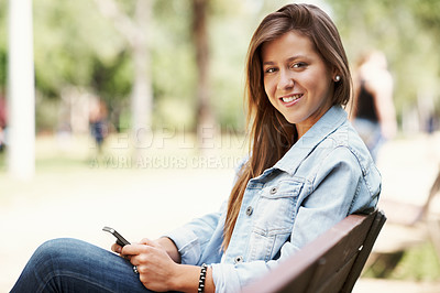 Buy stock photo Attractive young teen using her mobile while outdoors