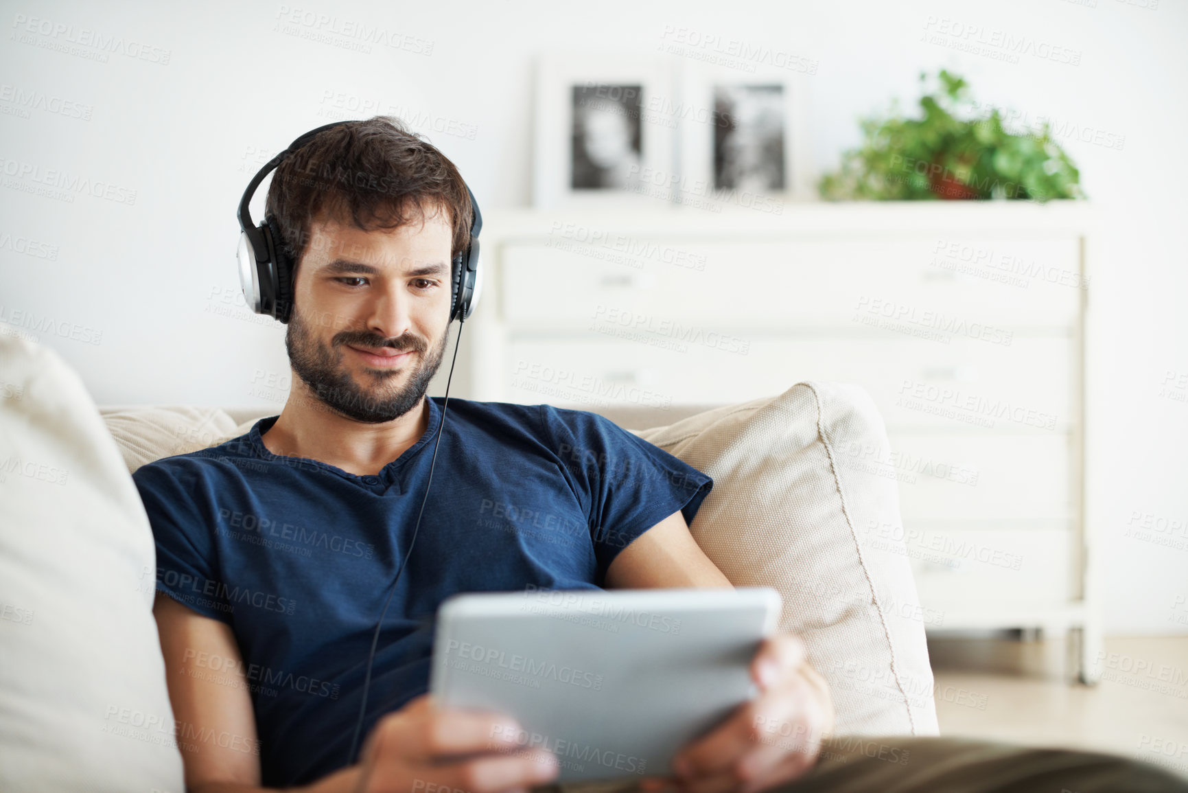 Buy stock photo Relax, man and headphones with tablet in home for streaming series, online video or holiday break. Smile, person or audio tech on sofa for tv show subscription, watching film or weekend entertainment