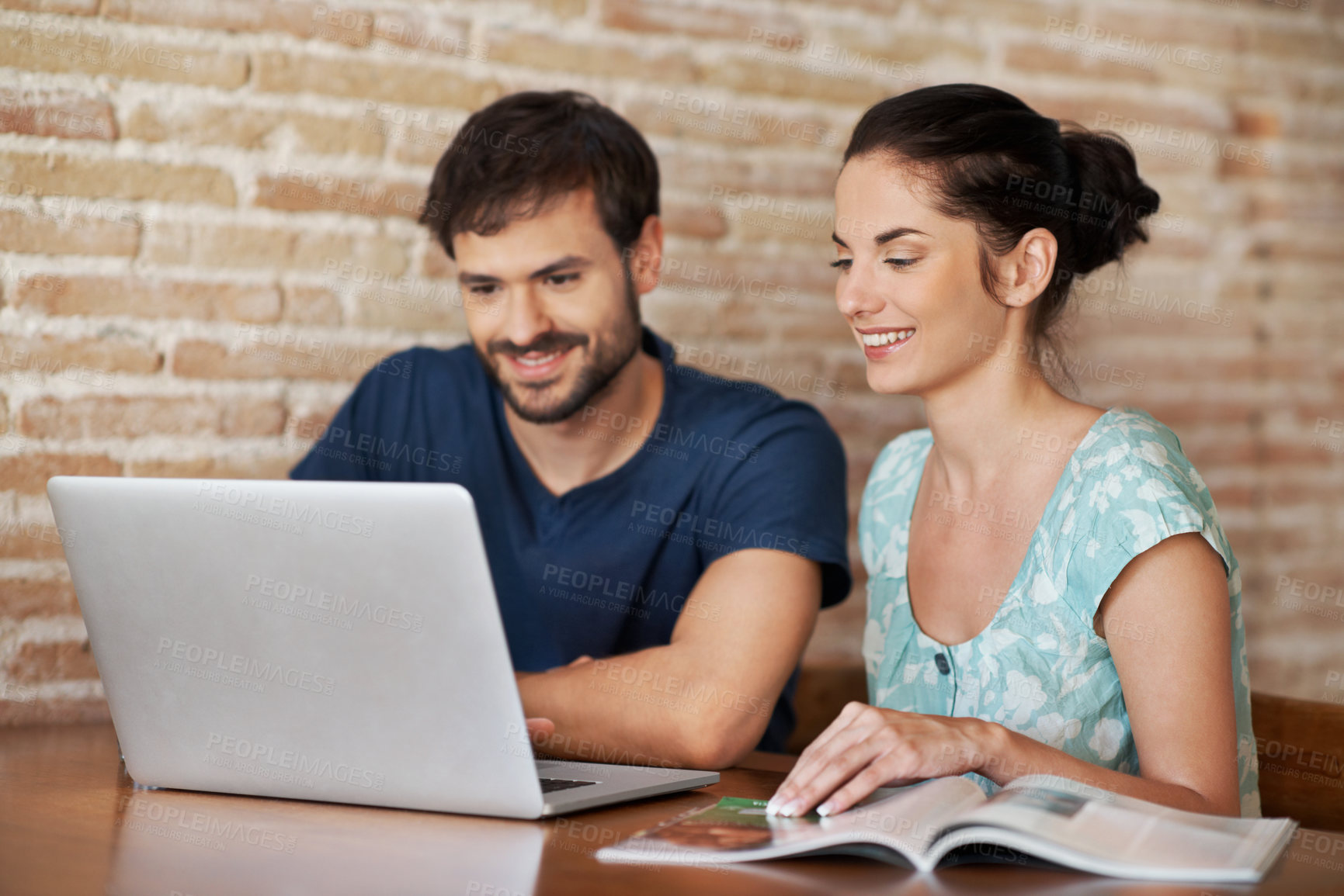 Buy stock photo Laptop, magazine and smile with couple in home for honeymoon trip, romantic vacation or love. Travel itinerary, online holiday package and tour catalogue with man and woman in dining room in house