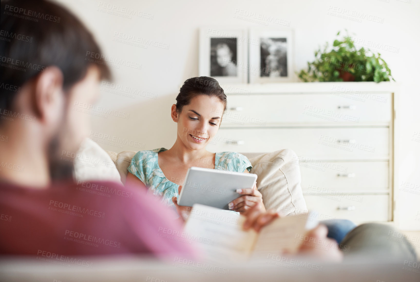 Buy stock photo Book, tablet and streaming with couple on sofa in home smile, bonding and relax with ebook. Virtual library, support and connection with woman and man in living room in house for peace and reading