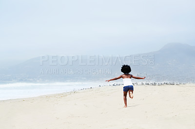 Buy stock photo Rear-view of a little African-American girl running on the beach towards the seagulls