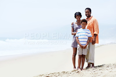Buy stock photo A young African-American family standing with their young son on the beach