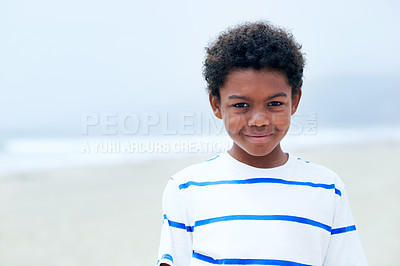 Buy stock photo A happy young African-American boy standing on the beach