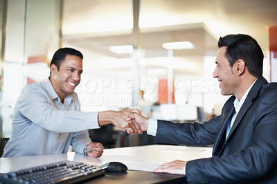 Buy stock photo Two coworkers showing agreement with a handshake