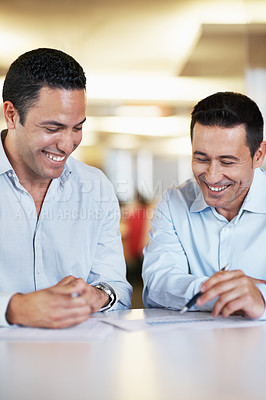 Buy stock photo Two businessmen expressing positivity over some paperwork