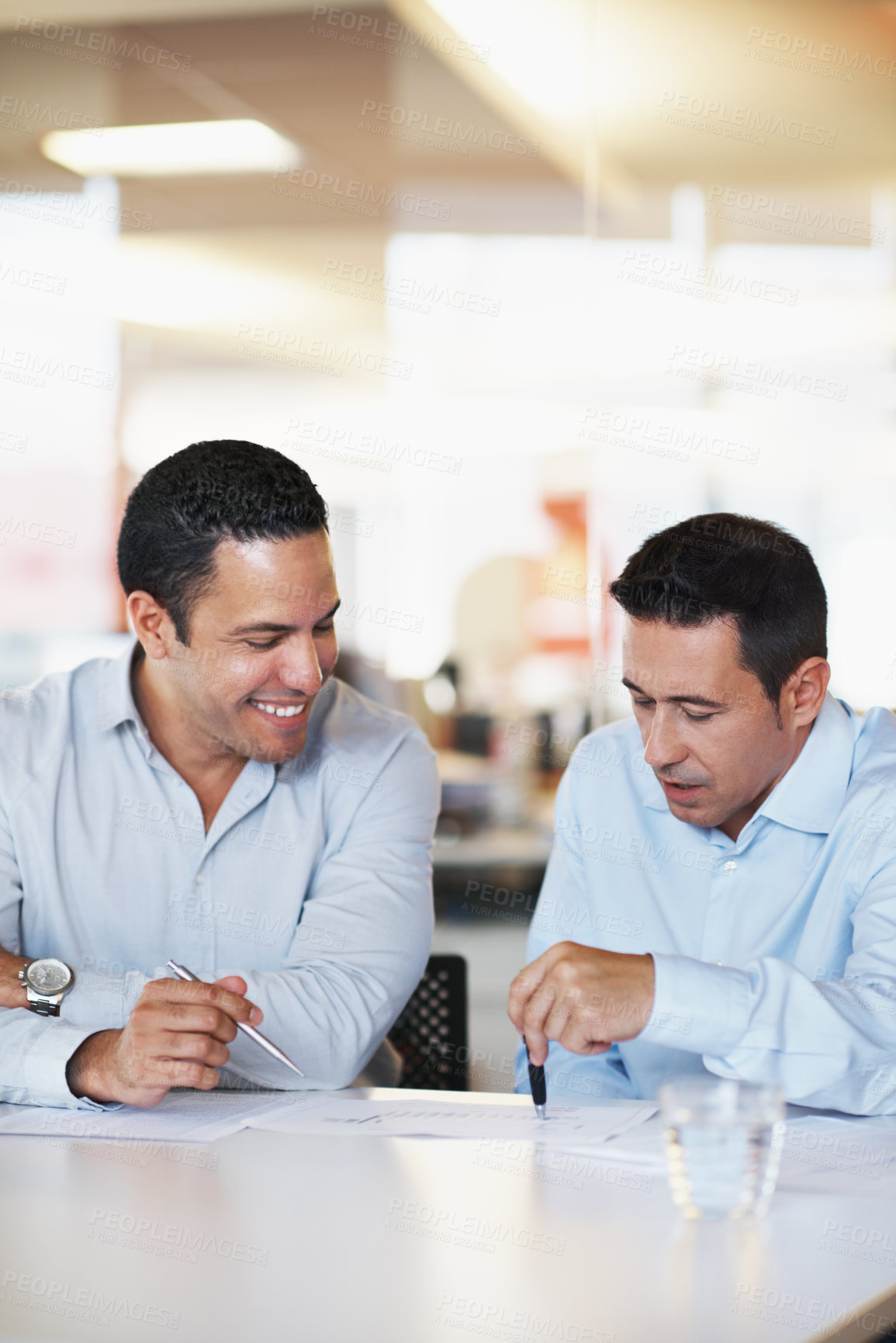 Buy stock photo Two coworkers having a meeting and discussing business projections
