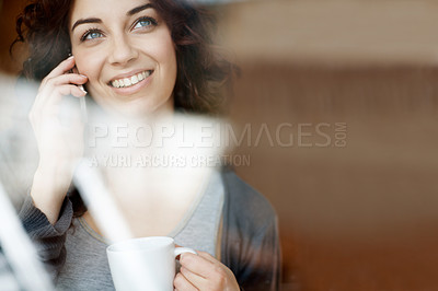 Buy stock photo A young woman talking on her cellphone while looking out of her window - copyspace