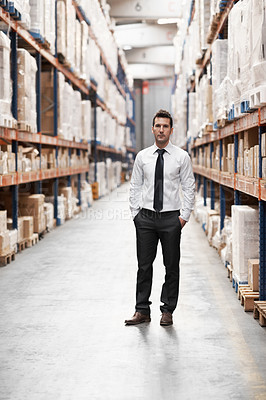 Buy stock photo Handsome warehouse manager standing in the warehouse surrounded by boxes