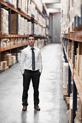 Buy stock photo Handsome warehouse manager standing in the warehouse surrounded by boxes