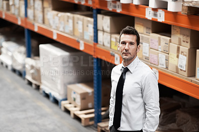 Buy stock photo Handsome warehouse manager standing in a warehouse with his hands in his pockets