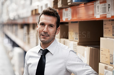 Buy stock photo Relaxed warehouse manager standing in a warehouse surrounded by boxes