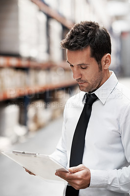 Buy stock photo Focused warehouse worker doing a stocktake while in a warehouse
