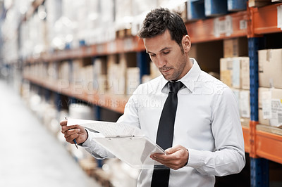 Buy stock photo Focused warehouse worker doing a stocktake while in a warehouse