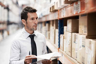 Buy stock photo Focused warehouse worker doing a stocktake while in a warehouse