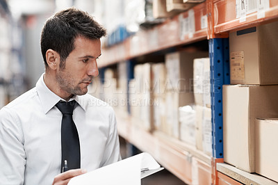 Buy stock photo Focused warehouse worker doing a stocktake while in a warehouse