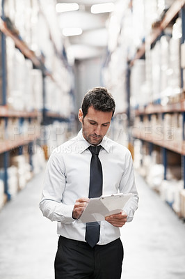 Buy stock photo Focused warehouse worker doing a stocktake while in a warehouse