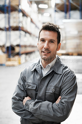 Buy stock photo Portrait of a handsome warehouse worker smiling with his arms folded