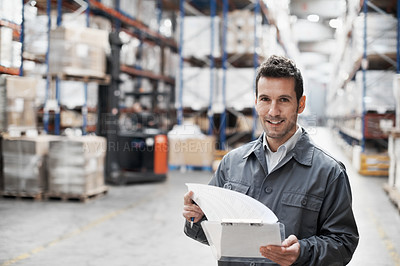Buy stock photo Handsome warehouse worker doing a stocktake while in a warehouse