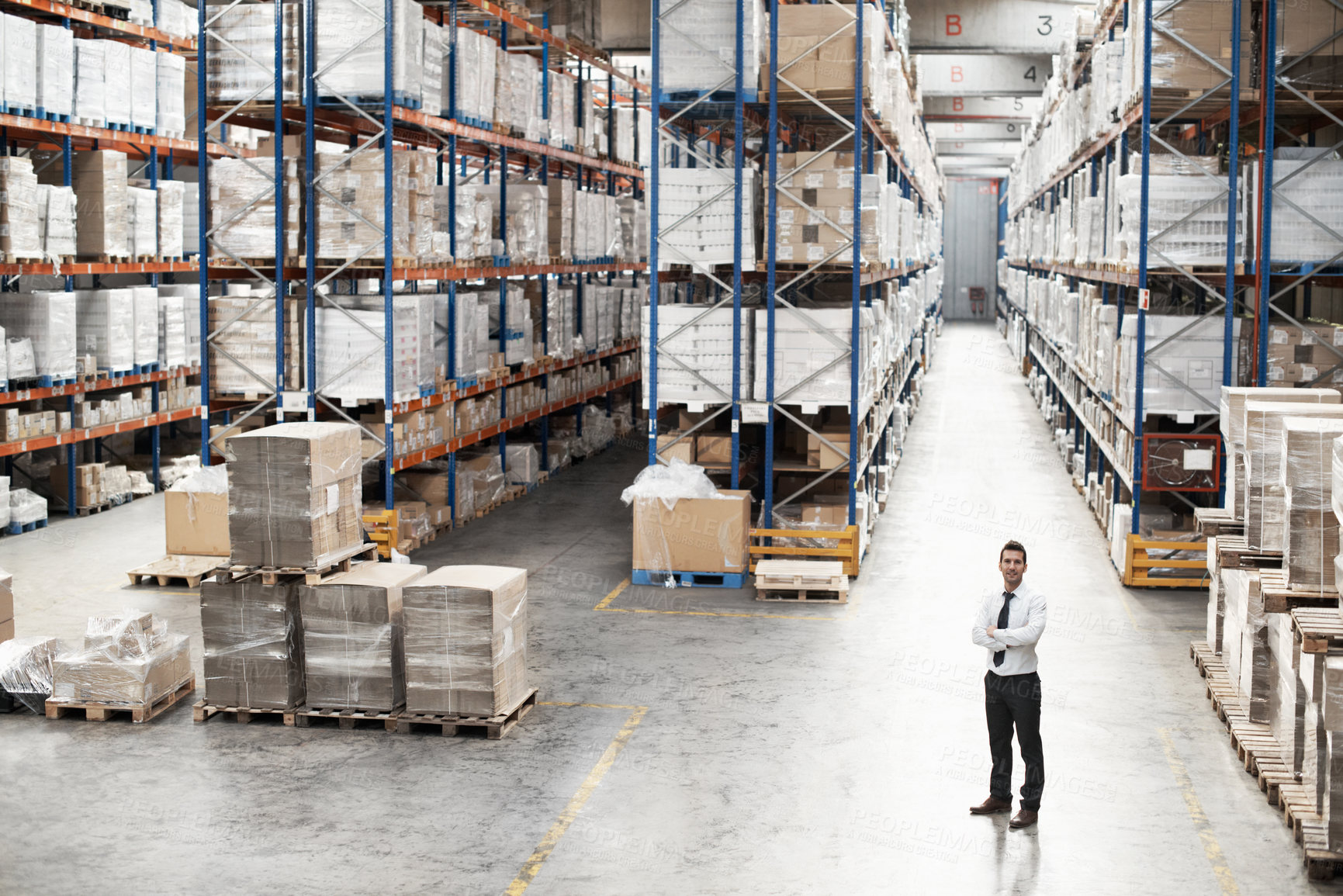 Buy stock photo Man, arms crossed and portrait in warehouse with stock, distribution and export management. Above, distributor and confident in storage depot for inventory control, logistics and supply chain service